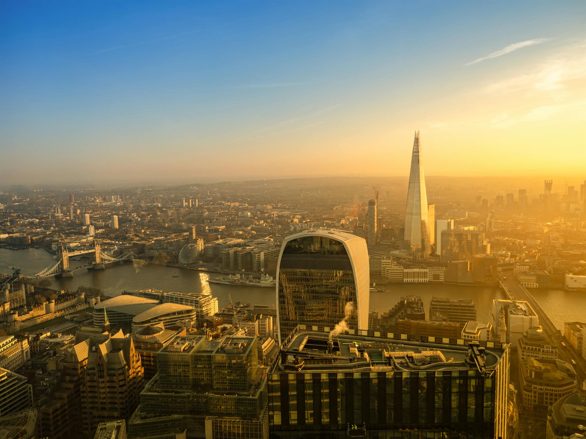 London skyline with the Walkie Talkie, the Shard, and Tower Bridge at sunset